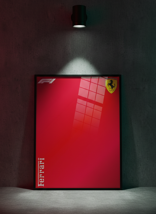 A framed Ferrari F1 poster with a bold red background and yellow prancing horse logo, leaning against a dark textured wall under a spotlight.
